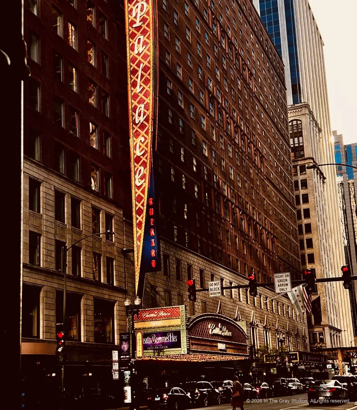 A Chicago block in warm light, theatre marquee and banners running down the facade